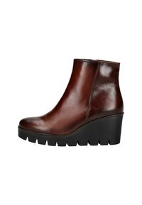 Bottines en cuir marron avec un design épuré, un bout arrondi et un talon compensé. Présentent une semelle en caoutchouc noir texturé. Fermeture éclair sur le côté.