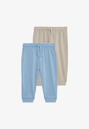 Dwie pary miękkich spodni dresowych: jedna w jasnym niebieskim kolorze z ściągaczami i sznurkiem, druga w beżowym z podobnymi cechami.