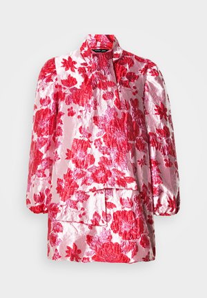 Λουλουδάτη μπλούζα με γυαλιστερή, ροζ βάση και κόκκινα λουλουδάτα μοτίβα. Διαθέτει μακριά, φουσκωτά μανίκια και ψηλό γιακά, με στρωματοποιημένες λεπτομέρειες μπροστά.