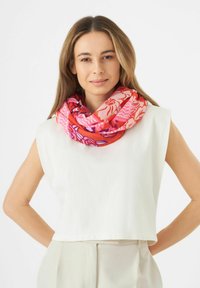 Multicolored sjaal met bloemen- en geometrische patronen in rood, roze en paars, gemaakt van zachte stof, gedragen in een lus om de hals.