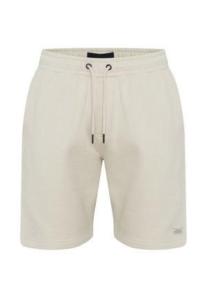 Beige bomullsshorts med elastisk midje og snor. Har sidelommer og en liten etikett på nedre høyre søm.