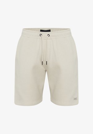 Pantalones cortos de algodón beige con cinturilla elástica y cordón. Cuenta con bolsillos laterales y una pequeña etiqueta en el dobladillo inferior derecho.