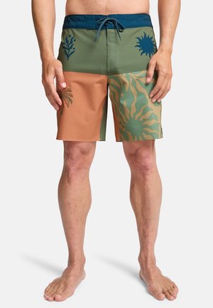 Kąpielówki męskie o wielokolorowym wzorze; składają się z zielonych, beżowych i koralowych części z tropikalnymi wzorami oraz elastycznym paskiem w talii.