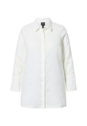 Camicia bianca di lino con colletto tailored, maniche lunghe e taglio dritto. Presenta una chiusura frontale con bottoni e un tessuto testurizzato.