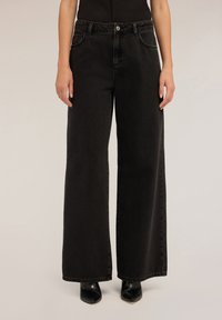 Schwarze Jeans im weit geschnittenen Design mit klassischem Fünf-Taschen-Stil, Metallknopfverschluss und leicht verblichenem Material.