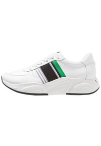 Białe sneakersy z fakturowaną czarną siateczką, ozdobione zielonymi i dwoma szarymi paskami po bokach. Okrągły czubek i masywna biała podeszwa.