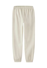 Jasnobeżowe spodnie z elastycznym pasem i zwężanymi nogawkami. Wykonane z gładkiej tkaniny, z marszczonymi mankietami i minimalistycznym designem.