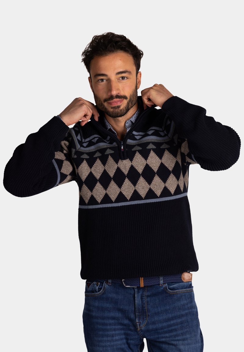 Marineblauwe gebreide sweater met een half-rits kraag, voorzien van een geometrisch ruitpatroon in beige en grijs over de borst. Gestructureerde stof.