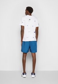 Nike Sportswear M NSW SPE WVN LND FLOW SHORT - Calças de fato de treino - marina blue/white