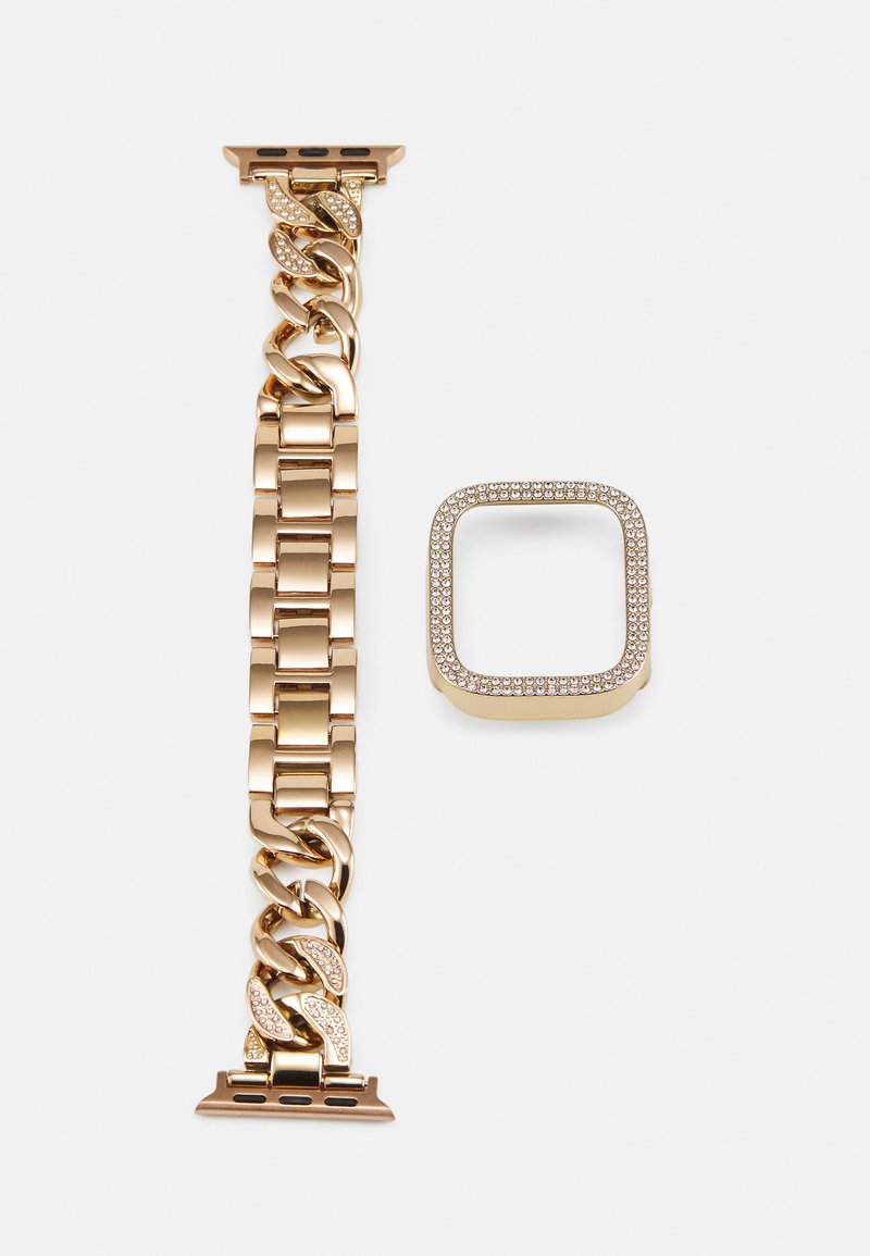 A pulseira do relógio em metal dourado apresenta elos interligados com um design de corrente e realces em strass. Inclui uma moldura quadrada cravejada de strass.