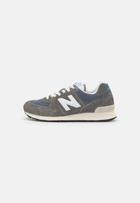 Sneakers in suede grigio con linguetta in rete blu navy, logo "N" bianco e suola chiara. Presenta dettagli blu sulla linguetta.