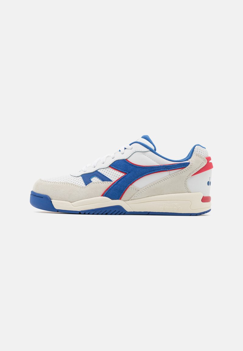 White and grey sneaker with blue and red accents, featuring a mix of suede and mesh materials, a rounded toe, and a textured rubber sole.