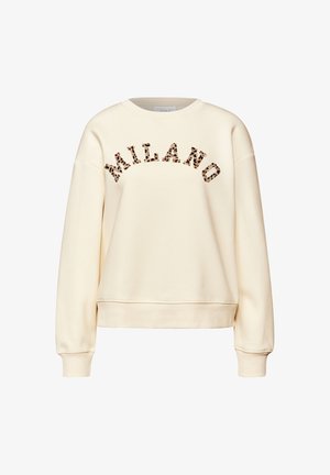 Kermanvärinen collegepaita, jossa on pyöreä pääntie ja lasketut olkapäät. Rinnassa leopardikuvioinen "MILANO"-teksti.