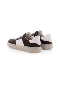 Braune Wildledersneaker mit weißen Lederakzenten, Gummisohle, runder Spitze und Schnürdesign. Profilansicht, die die Ferse und die seitlichen Details zeigt.