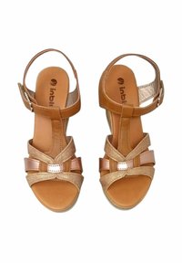 Sandali aperti in pelle color beige con una texture intrecciata e un accento metallico rosa. Presentano una cinghia alla caviglia e una suola imbottita per il massimo comfort.