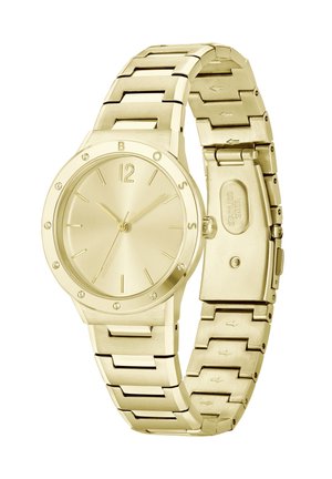 Montre-bracelet dorée avec un bracelet en métal élégant, cadran rond, marqueurs d'heure minimalistes et ornée de petites pierres autour de la lunette.