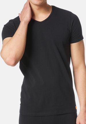 Schwarzes Kurzarm-V-Ausschnitt-T-Shirt aus weicher Baumwolle, mit slim fit und einem kleinen orangefarbenen Logo-Tag am Saum.