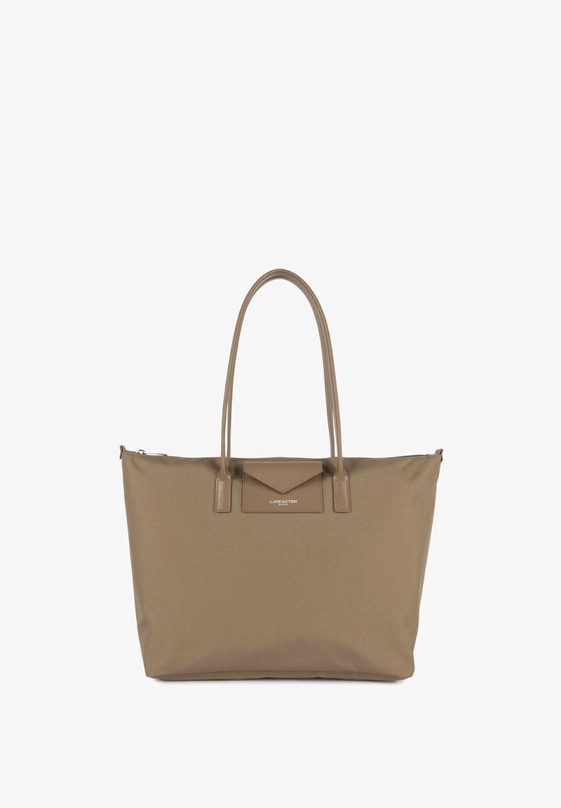 Sac cabas beige avec deux poignées, poche avant à rabat et logo Lancaster Paris, en tissu lisse.