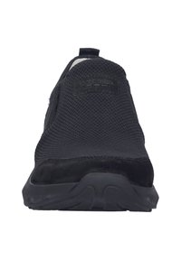 Černá sportovní bota s texturovaným síťovaným svrškem a akcenty z semiše. Obsahuje gumovou podešev a poutko na patě.