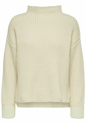 Pull à col roulé en tricot épais de couleur beige crémeux. Texture côtelée avec épaules tombantes, coupe ample et manches à bords-cousus.