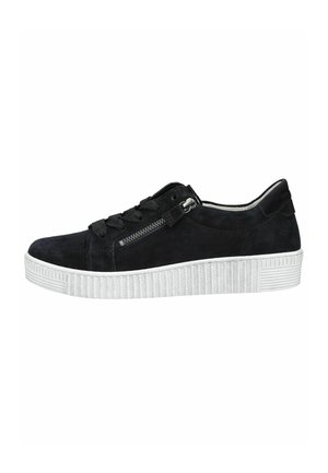 Black low-top suede sneaker with white thick ridged sole, black laces, and a functional silver zipper on the side.