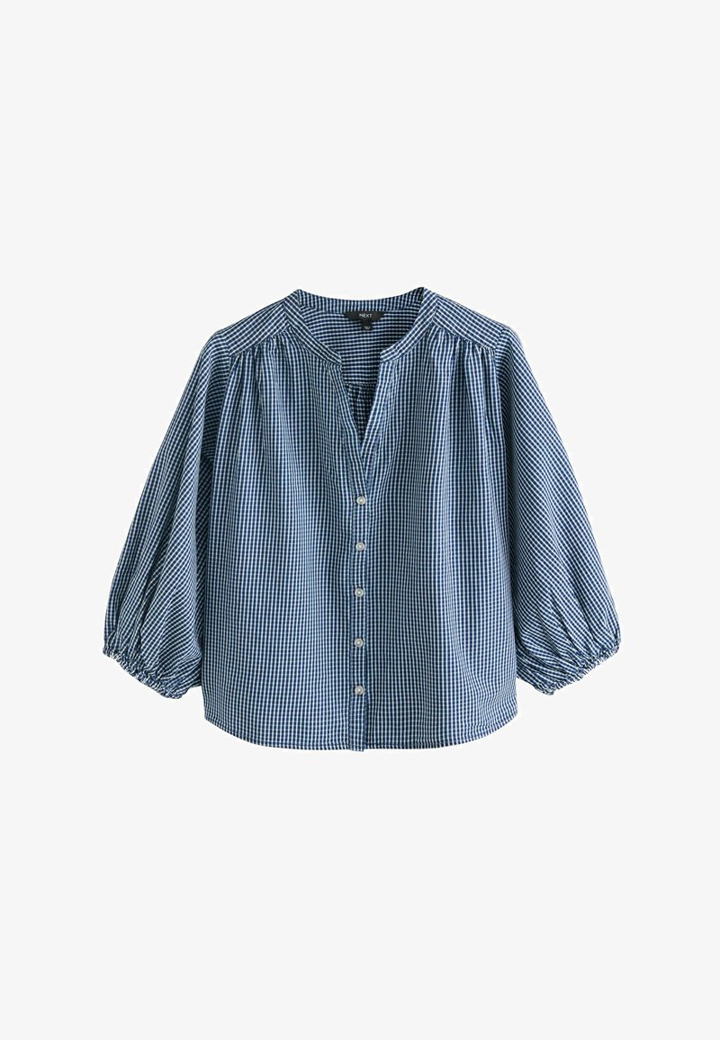 Blouse à carreaux bleus et blancs avec manches longues bouffantes, fermeture boutonnée à l’avant et petit col rond.