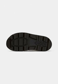 Suola di scarpa nera con scanalature profonde e larghe e un motivo testurizzato per una maggiore aderenza e durata su sfondo bianco puro.