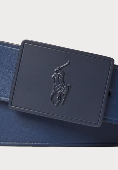 Sötétkék bőr öv, téglalap alakú csattal, melyen egy dombornyomott lovas design található. Simasága és elegáns megjelenése jellemzi.