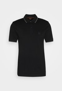 Polo noir à manches courtes avec deux boutons, bordure grise sur le col et les bords des manches, et un petit écusson logo sur la poitrine gauche.