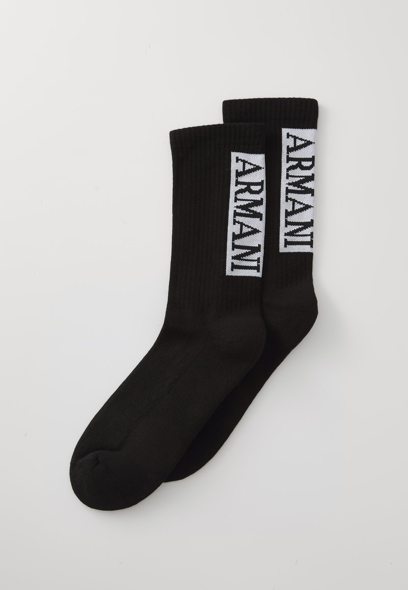 Fekete bordás zoknik, amelyek szélén függőlegesen fehér "ARMANI" felirattal díszítettek. Puha, rugalmas anyagból készültek, sima tapintással.