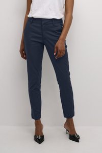 Hosen in Marineblau, maßgeschneidert aus einem Baumwollmix, mit schmalem Schnitt, vorderen Taschen und glatter Textur, kombiniert mit schwarzen High Heels.