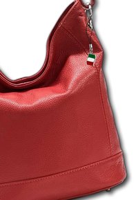 Rode leren handtas met een gladde textuur, ronde vorm en een klein Italiaans vlaggetje als bedeltje aan de schouderriem.