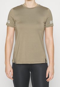 Camiseta de manga corta color verde oliva con cuello redondo, aberturas en los lados del dobladillo y texto "BORG" en blanco en la manga izquierda. Textura de tela suave.