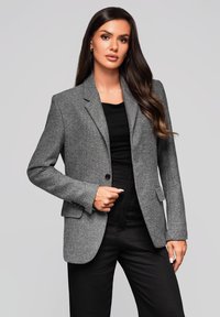Šedý tailored blejzr z texturované látky, s klopovými límci, zapínáním na jeden knoflík a předními kapsami, spárovaný s černým topem.