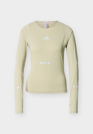 Langärmeliges Sportoberteil aus hellgrünem Stoff mit reflektierenden weißen Akzenten, rundem Ausschnitt und figurbetontem Schnitt. Weiche, leichte Textur.