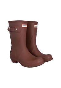 Botas de lluvia de goma marrones con un acento de hebilla en el lateral y el logotipo "HUNTER". Textura lisa y diseño de puntera redondeada con una suela con relieve.