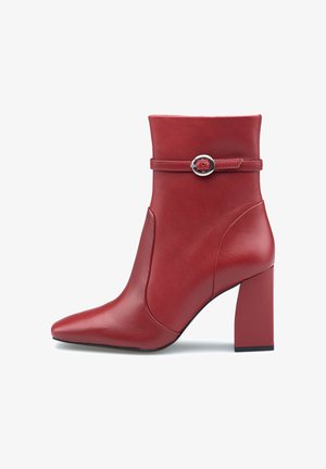 Rote Leder-Stiefelette mit spitzem Fuß, einem Reißverschluss und einem breiten Blockabsatz. Besitzt einen dünnen Riemen mit einer runden Metallschnalle.