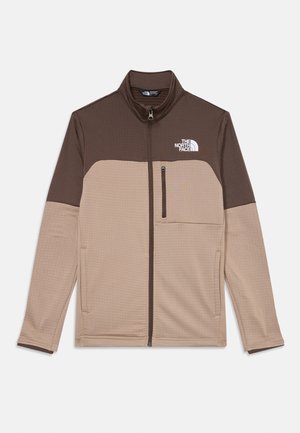 Veste en polaire pour homme avec une section supérieure marron, une section inférieure beige clair, fermeture éclair à l'avant et logo sur la poitrine gauche. Tissu texturé.