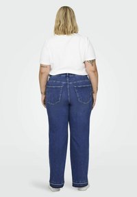 Denim jeans in a dark blue hue, featuring a high waist, straight-leg fit, and two back pockets. Paired with a white short-sleeve T-shirt.