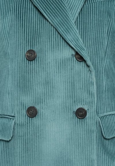 Cappotto doppiopetto in corduroy teal con texture a coste verticali, bottoni neri e rever a tacca. Tasche frontali e design sartoriale.