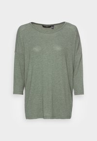 Vihreä, kevyt pitkähihainen paita rentolla istuvuudella, jossa on pyöreä pääntie ja pehmeä, teksturoitu kangas.