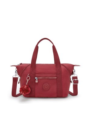 Sac à main en tissu rouge avec doubles poignées, bandoulière ajustable, poche zippée à l'avant, écusson logo rond et un petit porte-clés singe en peluche.