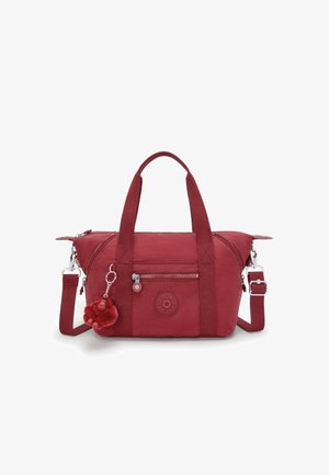 Rote Stoffhandtasche mit doppelten Griffen, verstellbarem Schulterriemen, vorderer Reißverschlusstasche, rundem Logo-Patch und einem kleinen Plüsch-Affen-Schlüsselanhänger.