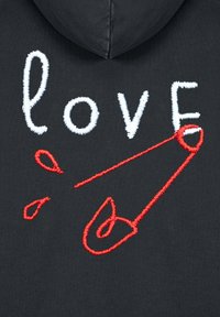Felpa nera con cappuccio caratterizzata da testo ricamato bianco che dice "love" e un design di spilla di sicurezza rossa con due accenti a goccia rossa.
