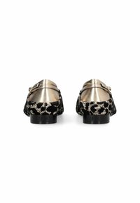 Mocassins noirs avec un dos en métal doré et un tissu à motifs. Texture lisse avec une semelle plate et un détail de sangle sur le côté.