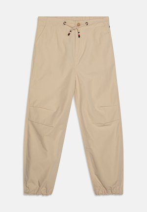 Beige cargo broek met een elastische tailleband, trekkoordsluiting, zijzakken en elastische cuffs bij de enkels. Soepele, lichte stof.
