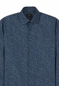 Langarm-Hemd mit Knopfleiste in dunklem Marineblau, mit einem gepunkteten Muster in Hellblau und Braun. Verfügt über einen Standardkragen und sechs Knöpfe.