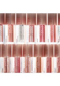 Maybelline Lifter Gloss lip gloss tubes arranged in rows. Clear bottom with pink tops, varying shades of pink, peach, brown, and sheer.