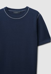 Marineblaue kurzärmelige T-Shirt aus Strickstoff, mit rundem Ausschnitt mit weißer Naht und einem Etikett am Halsausschnitt.