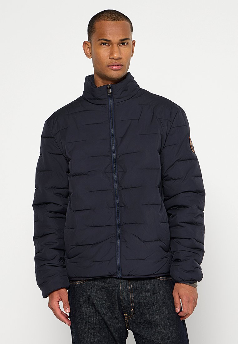 Marineblaue Steppjacke mit horizontalem Steppmuster, hohem Kragen und Reißverschluss. Verfügt über ein Logopatch am Ärmel und elastische Bündchen.